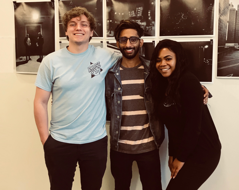 Center for Sustainable Journalism’s student experiential learning graduates in front of a Bokeh_Focus photo gallery display. From left to right: Gabe Valeanu, Ali Sardar, Zori Perkins.